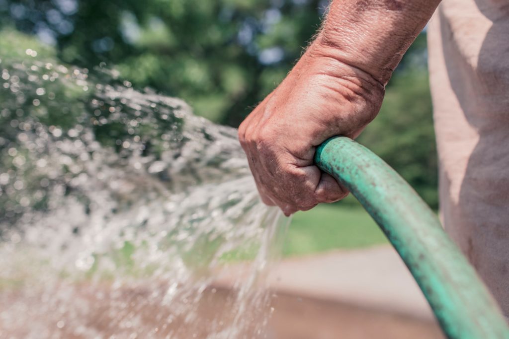 Water coming out from hose held by hand